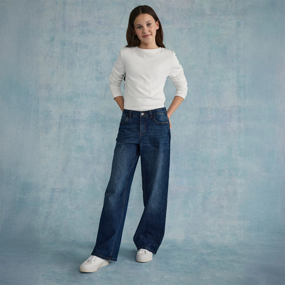 Top alb texturat, combinat cu blugi largi și adidași albi.