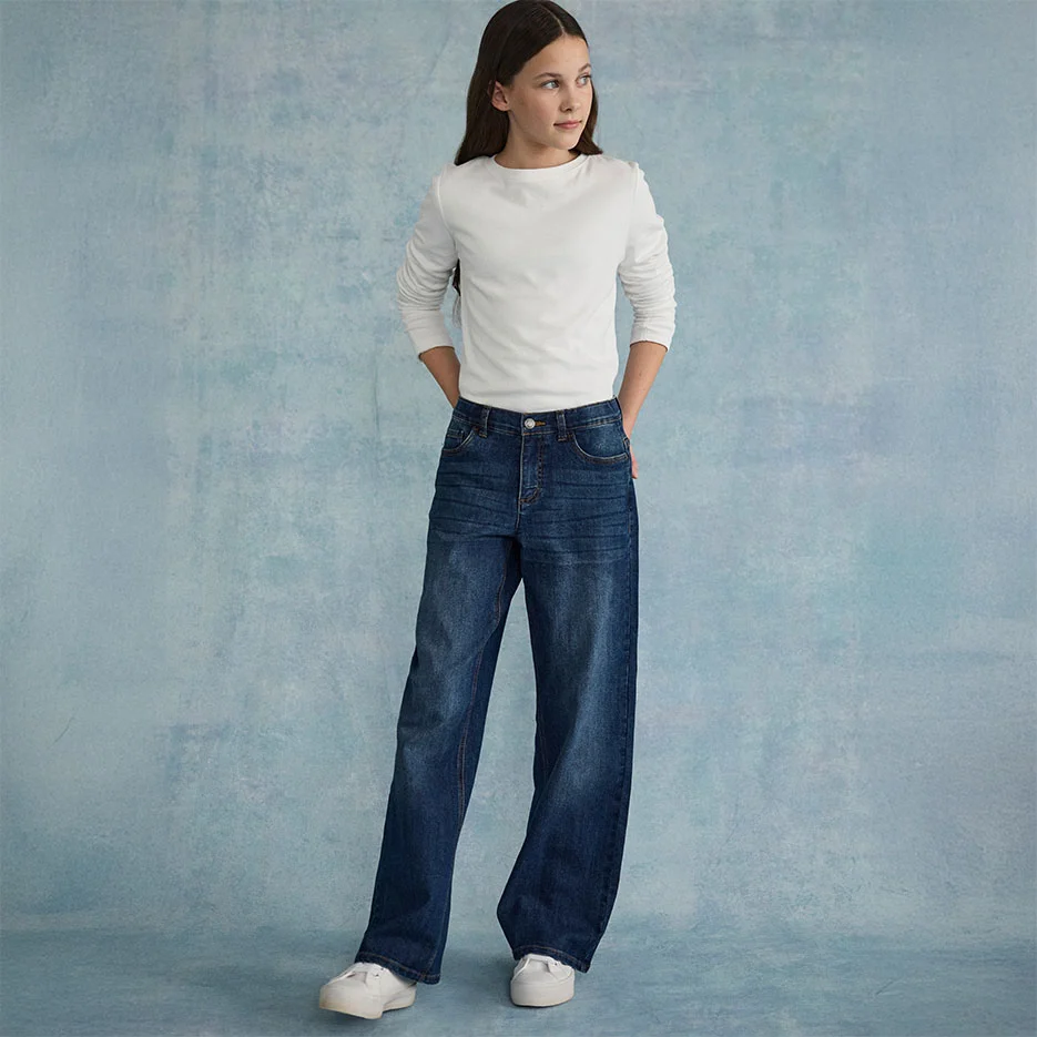 Top alb texturat, combinat cu blugi largi și adidași albi.