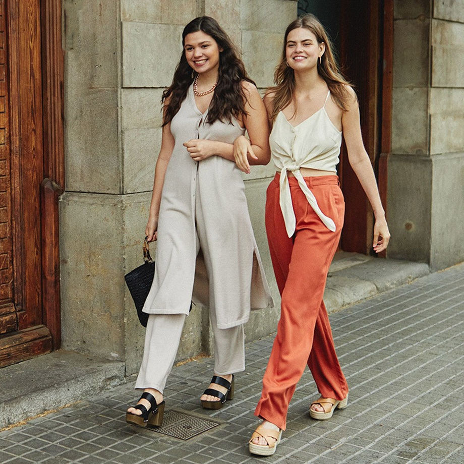 Eleganță estivală: costume deschise la culoare și topuri vaporoase, combinate cu pantaloni portocalii și espadrile.