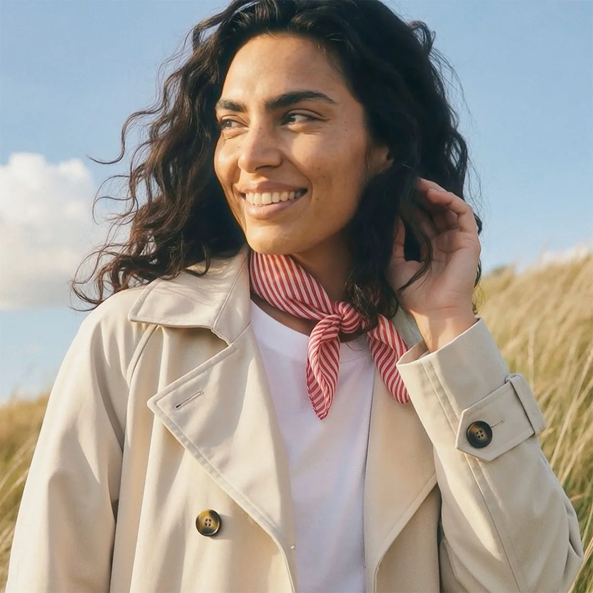 Trenchcoat bej cu bluză albă pe dedesubt.