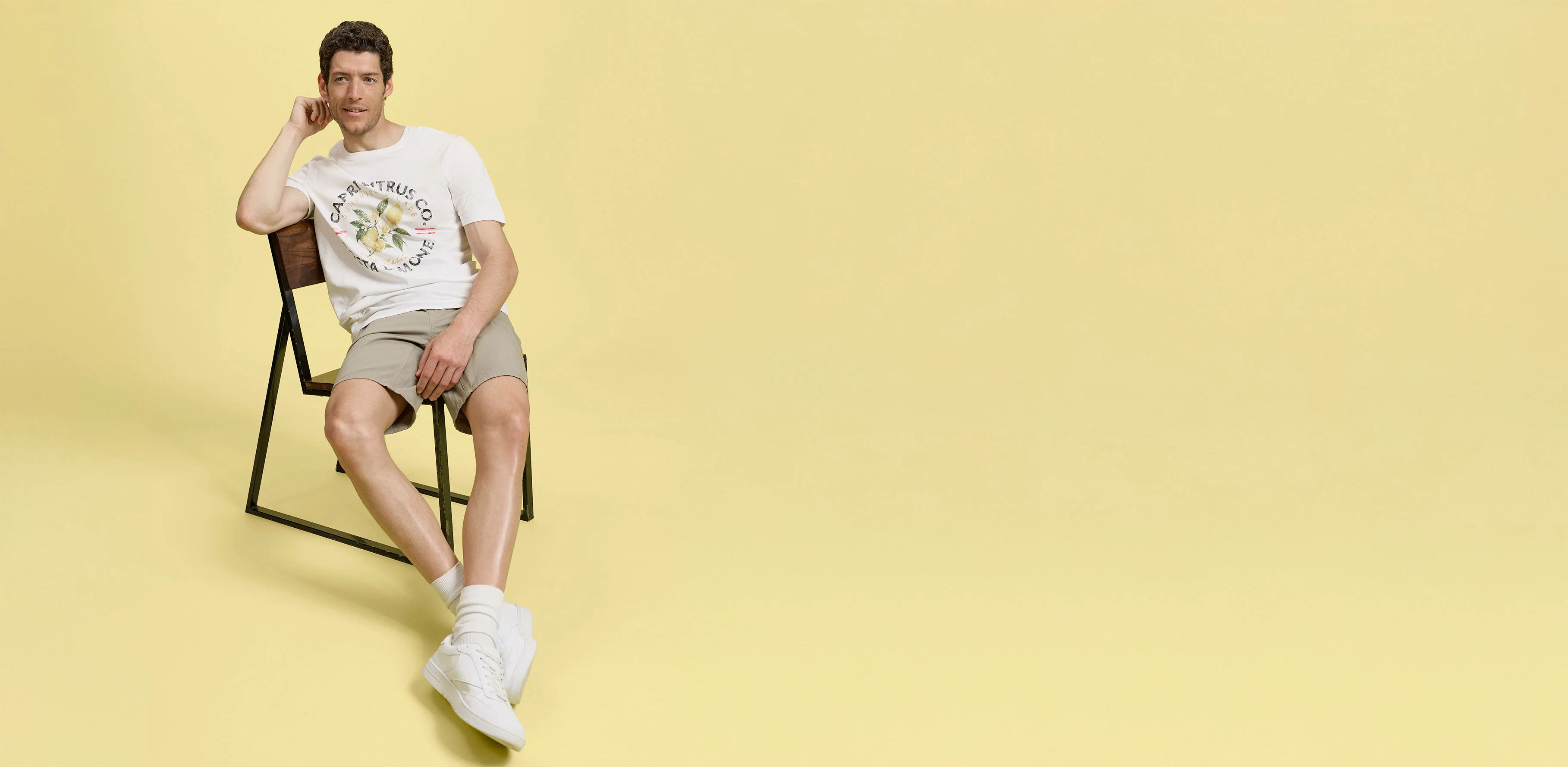 Look-uri de vară cu șort bej, tricou alb și sneakeri comozi.