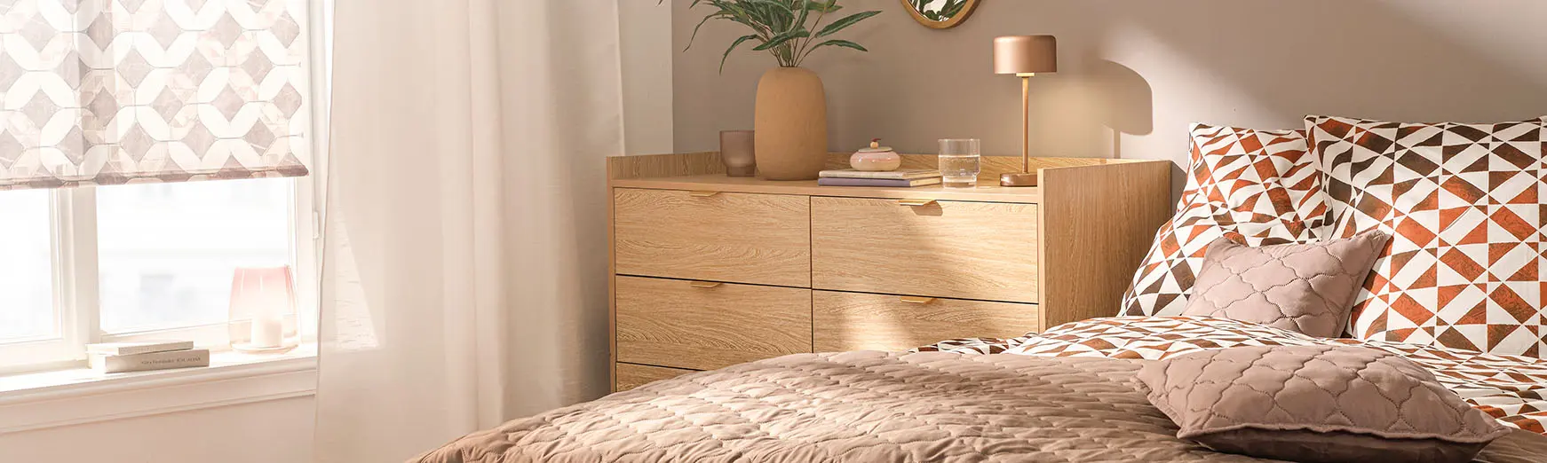 Lenjerie de pat cu model, cu nuanțe maro și oranj, plus cuvertură matlasată și pernă decorativă.